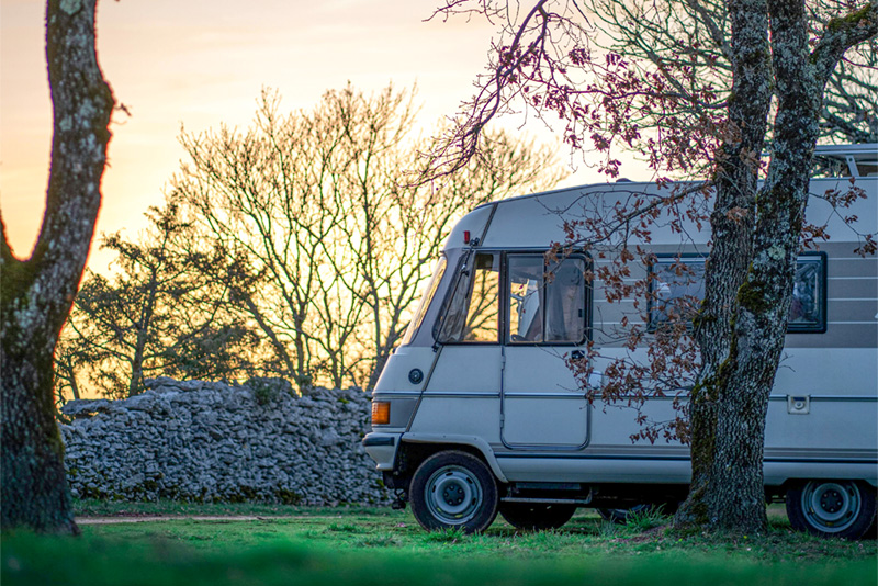 Recreational vehicle overlooking a sunset.
