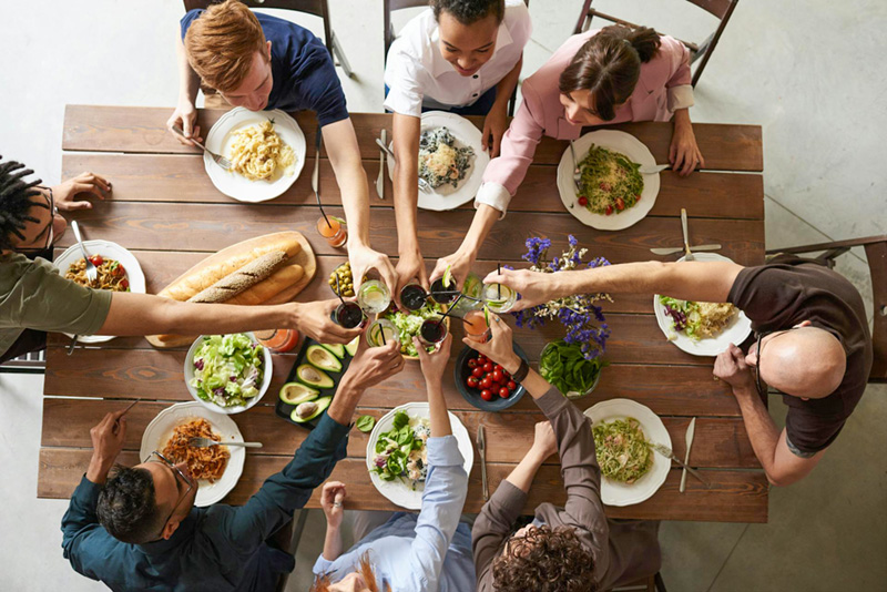 A group of people toasting at a harvest dinner.